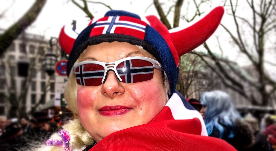 Person med norsk "vikinglue" og briller med norske flagg på linsene