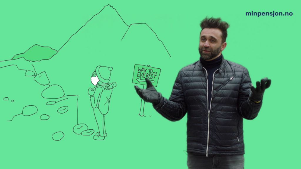 En mann står foran en green screen og gestikulerer. I bakgrunnen er det en animasjon av en gammel mann som går opp Mount Everest. Skjermbilde fra video.